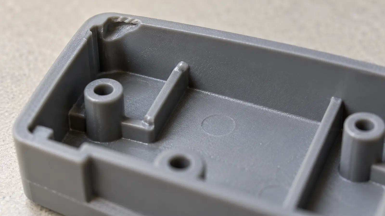 Close view of a molded plastic housing with an incomplete rib and an unfilled corner