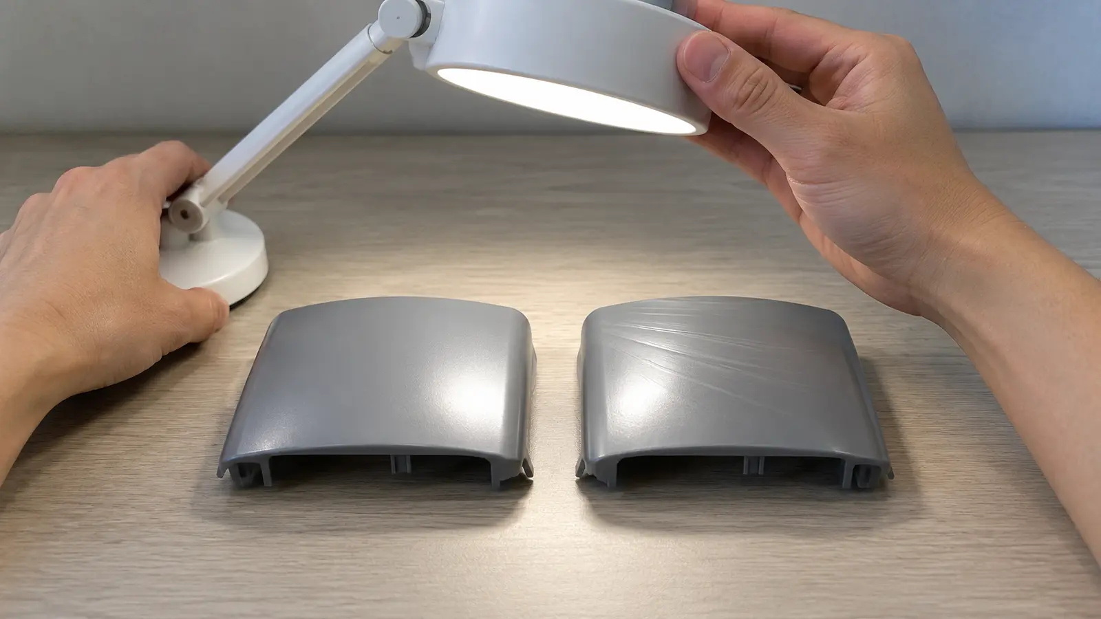 Two molded plastic samples compared under the same angled task light