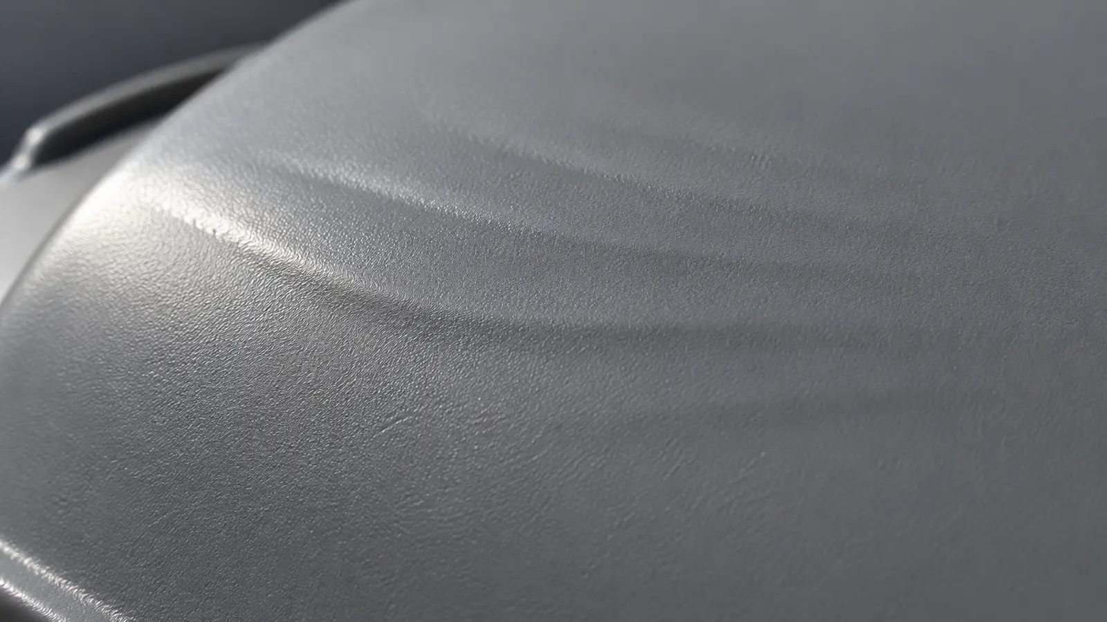 Flow lines in injection molding appear as shallow ripples and a gloss change on a gray molded plastic surface
